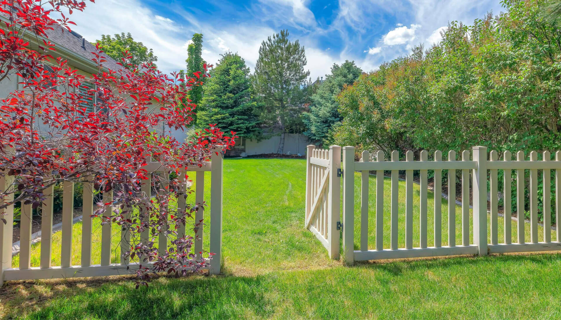 A functional fence gate providing access to a well-maintained backyard, surrounded by a wooden fence in Chesterfield